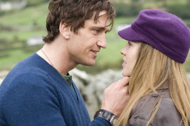 A man gently holds a woman wearing a purple hat in a romantic scene featuring Hilary Swank, HD Desktop Wallpaper