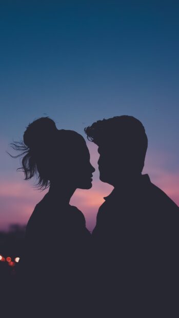 A romantic silhouette of a love couple against a colorful sunset sky, 4K Phone Wallpaper