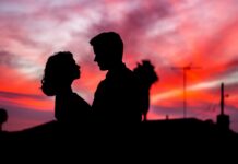 A love couple is shown in silhouette against a colorful sunset sky, 4K Desktop Wallpaper