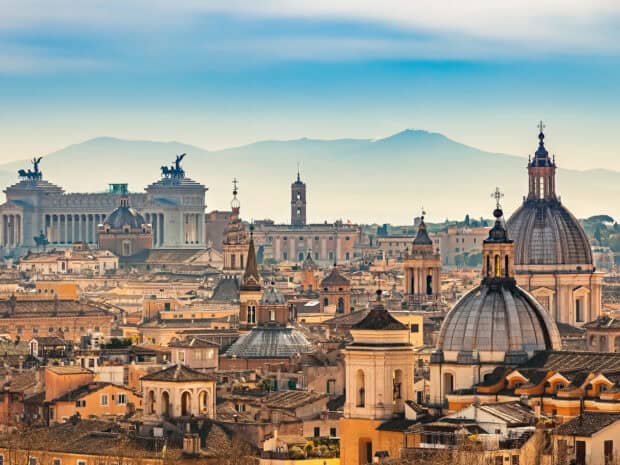 The Rome skyline at sunrise shows historical buildings and mountains in the background, HD Desktop Wallpaper