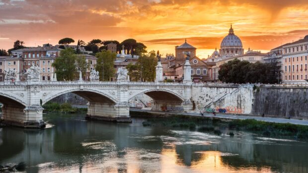The Rome skyline features a beautiful bridge and cathedral under an orange sky, 4K Desktop Wallpaper