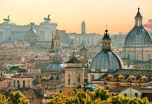 The Rome skyline features majestic domes and ancient architecture under a warm sky, 2K Desktop Wallpaper