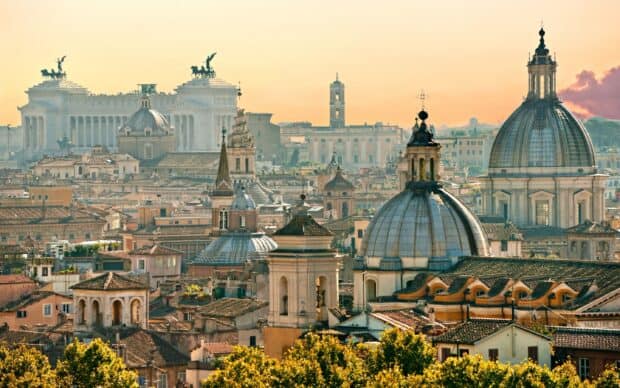The Rome skyline features majestic domes and ancient architecture under a warm sky, 2K Desktop Wallpaper
