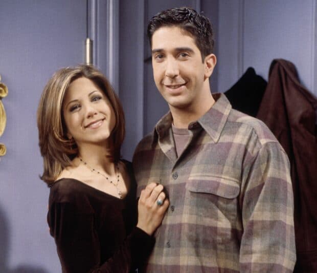 Ross from Friends stands with a smiling woman in a cozy indoor setting, HD Desktop Wallpaper