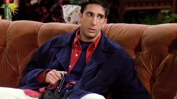 Ross from Friends character sits on a brown sofa looking to the side, HD Desktop Wallpaper