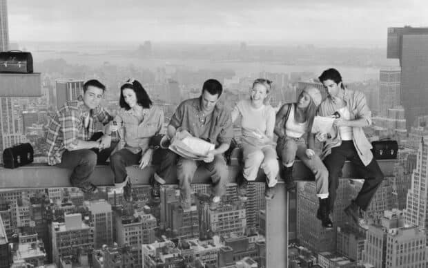 Ross friends sitting on a steel beam high above the city reading and eating food, 2K Desktop Wallpaper