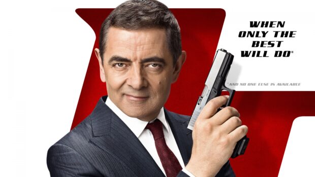 Rowan Atkinson holding a gun with a confident expression in front of a red and white background, 4K Desktop Wallpaper