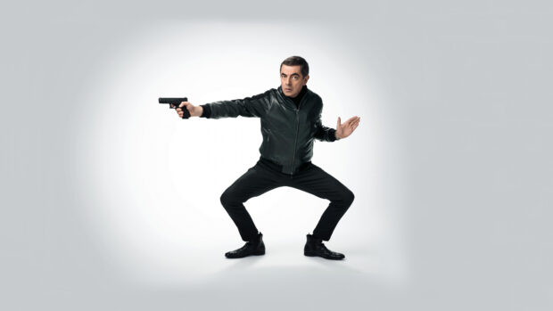 Rowan Atkinson is holding a gun in a dynamic stance, 4K Desktop Wallpaper