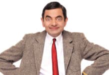 Rowan Atkinson wallpapers shows a man in a brown tweed jacket and red tie smiling, HD Desktop Wallpaper