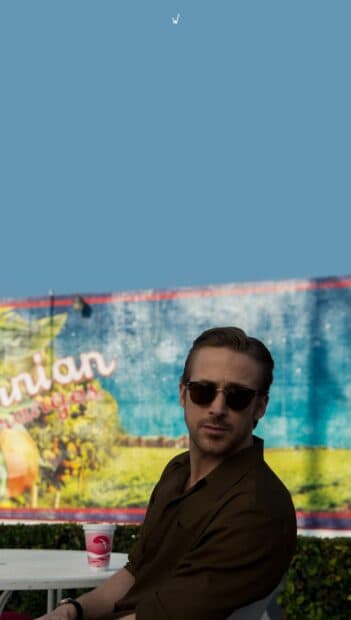 Ryan Gosling La La Land Wallpapers featuring a man wearing sunglasses seated by a colorful mural, HD Phone Wallpaper