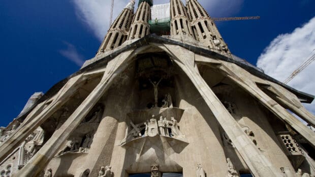 The Sagrada Familia features intricate sculptural details on its facade under a bright sky, 4K Desktop Wallpaper