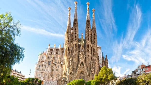 A stunning view of Sagrada Familia architecture under a clear blue sky in Barcelona city, 2K Desktop Wallpaper