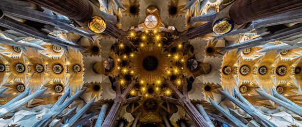 The Sagrada Familia ceiling features intricate architectural details with golden lights, 2K Desktop Wallpaper