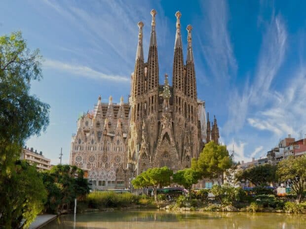 The Sagrada Familia stands tall under a blue sky with clouds, HD Desktop Wallpaper