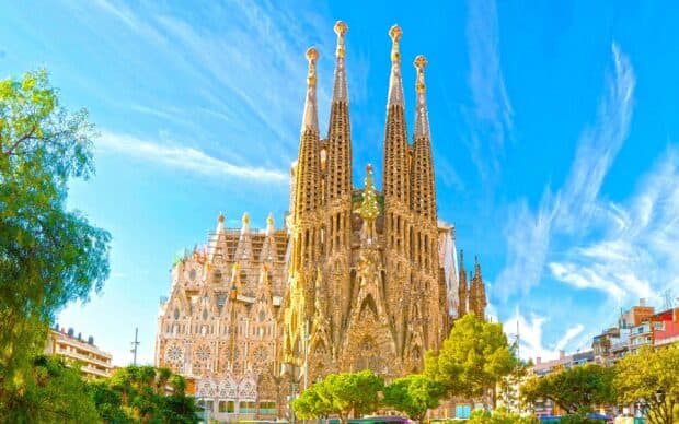 The Sagrada Familia displays intricate Gothic and modernist architectural details under a clear blue sky, 2K Desktop Wallpaper
