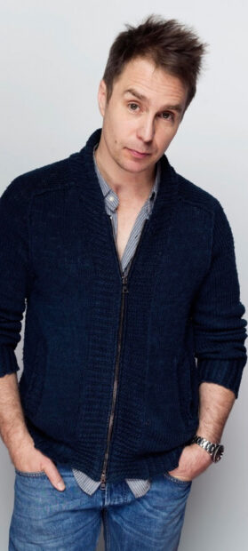 Sam Rockwell wears a navy sweater and jeans posing casually with hands in pockets, 2K Phone Wallpaper