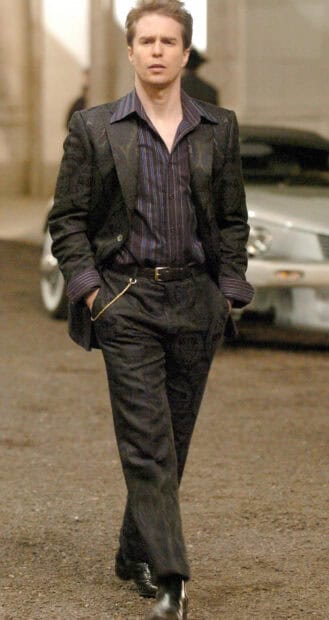 Sam Rockwell walking outdoors in a dark suit with hands in pockets, 2K Mobile Wallpaper