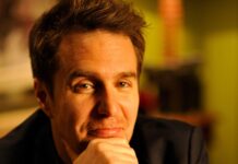 Sam Rockwell gazes thoughtfully with warm lighting, 2K Desktop Wallpaper