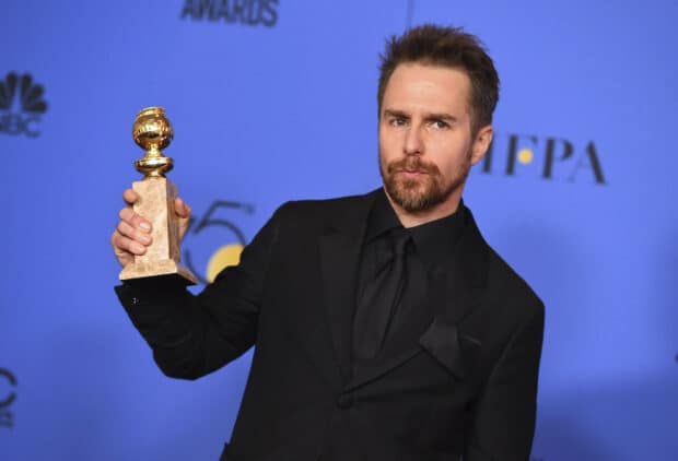 Sam Rockwell holding a golden trophy at an awards event in a black suit, 2K Desktop Wallpaper
