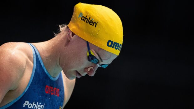 Sarah Sjostrom is concentrating before a race wearing a yellow swim cap and goggles, HD Desktop Wallpaper