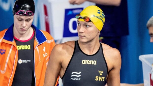 Sarah Sjostrom focused before a swim race wearing a yellow swim cap and black suit, HD Desktop Wallpaper