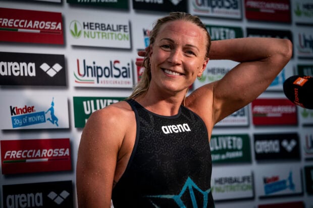 Sarah Sjostrom smiles confidently after a swimming race with visible sweat on her skin, HD Desktop Wallpaper