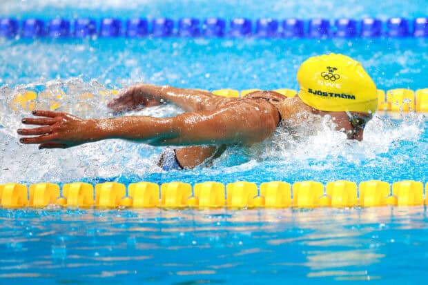 Sarah Sjostrom is swimming in a pool during a competitive event with water splashing around, 2K Desktop Wallpaper