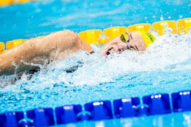 Sarah Sjostrom swims with determination in a blue pool wearing a yellow swim cap, HD Desktop Wallpaper