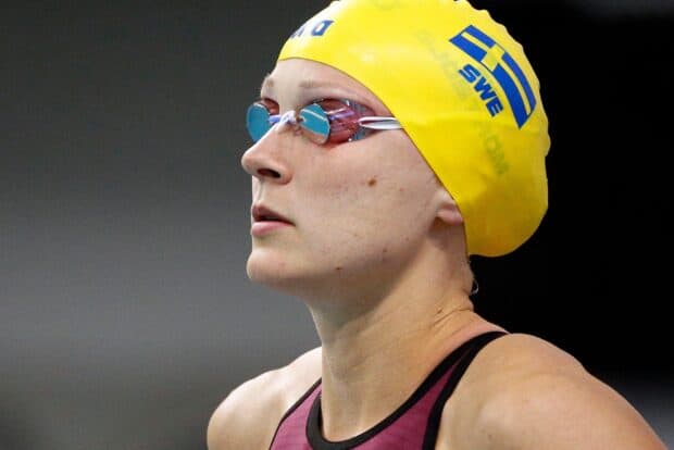 Sarah Sjostrom focused before swim competition wearing yellow cap and goggles, HD Desktop Wallpaper