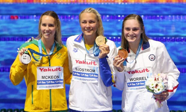 Sarah Sjostrom holding a gold medal at the swimming championship podium, HD Desktop Wallpaper