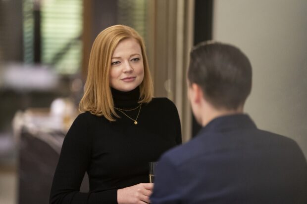 Sarah Snook engages in a conversation holding a glass indoors, 2K Desktop Wallpaper