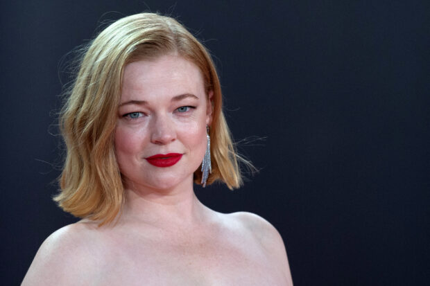 Sarah Snook looks confidently ahead with red lipstick and shoulder length blonde hair, 2K Desktop Wallpaper