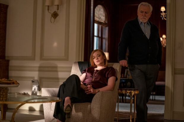 Sarah Snook is seated looking thoughtful while an older man stands nearby in a room, HD Desktop Wallpaper