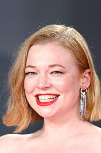Sarah Snook smiles brightly wearing red lipstick and dangling earrings, HD Phone Wallpaper