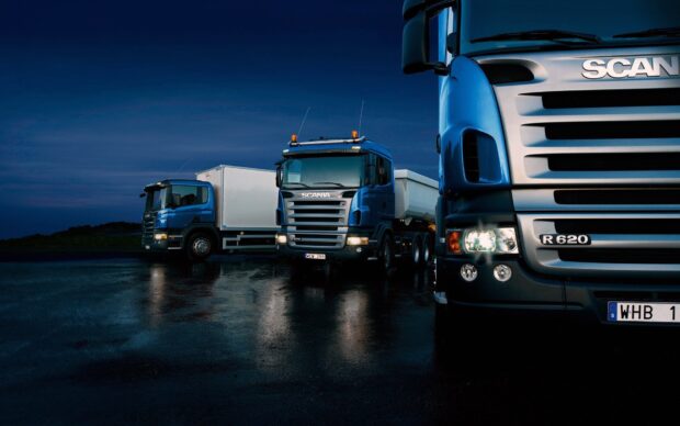 Blue Scania trucks are parked on a wet surface under the night sky, HD Desktop Wallpaper