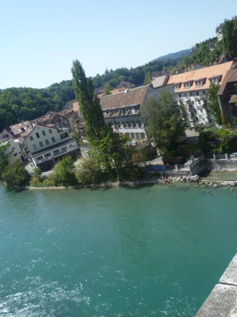 The River Aare flows beside historic buildings and lush trees in Switzerland, HD Desktop Wallpaper