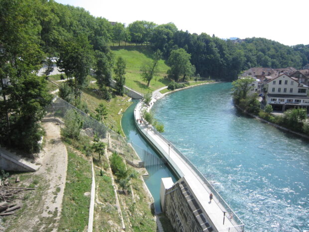 A clear view of River Aare in Switzerland surrounded by greenery and buildings, 2K Desktop Wallpaper