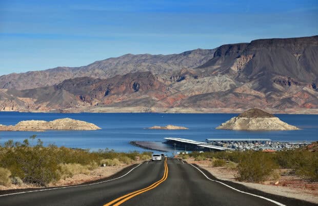 A clear road leads to the calm waters of Lake Mead surrounded by rocky mountains, HD Desktop Wallpaper