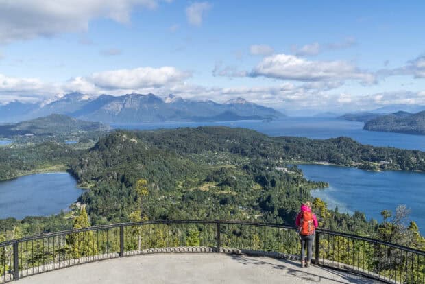 A hiker in a pink jacket enjoys the scenic Nahuel Huapi mountain and lake view, HD Desktop Wallpaper
