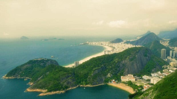 A panoramic view of Rio De Janeiro reveals its coastline and lush green hills on a misty day, HD Desktop Wallpaper
