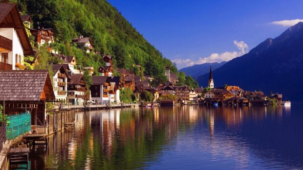 A picturesque village by the calm lake surrounded by lush green hills and mountains, HD Desktop Wallpaper