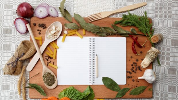 A blank notebook surrounded by seasoning ingredients like garlic, bay leaves, and chili peppers, HD Desktop Wallpaper
