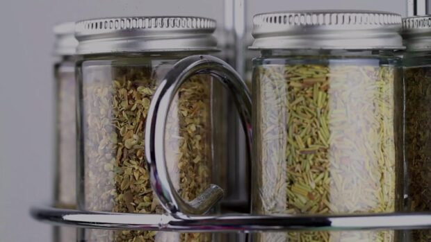 A close up of seasoning jars filled with various herbs and spices on a metal rack, HD Desktop Wallpaper