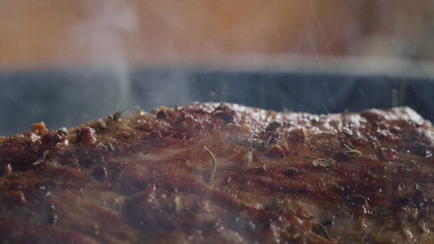 Close up of seasoning on grilled meat with herbs steaming, 4K Desktop Wallpaper