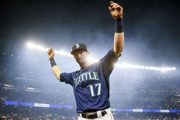 A Seattle Mariners player raises his arms during a night game in the stadium, HD Desktop Wallpaper