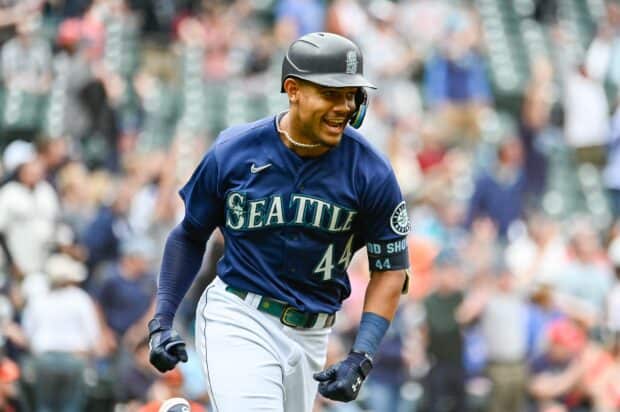 A Seattle Mariners player is smiling and running during a game in a packed stadium, HD Desktop Wallpaper