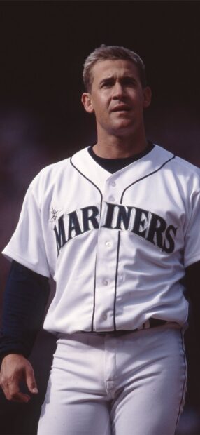 A Seattle Mariners player stands focused during the game wearing a white uniform, HD Mobile Wallpaper
