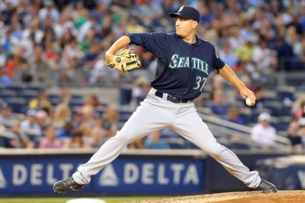 A Seattle Mariners player is pitching during a game in a crowded stadium, HD Desktop Wallpaper