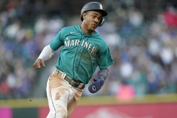 A Seattle Mariners player is running during a baseball game in a crowded stadium, HD Desktop Wallpaper