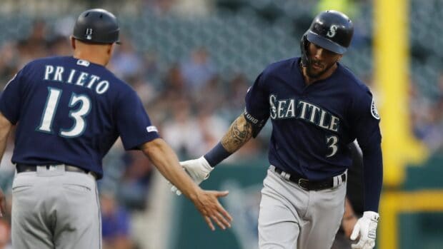 Two Seattle Mariners players high five during a baseball game in the stadium, 2K Desktop Wallpaper